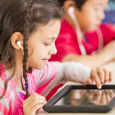 Student using tablet wearing headphones