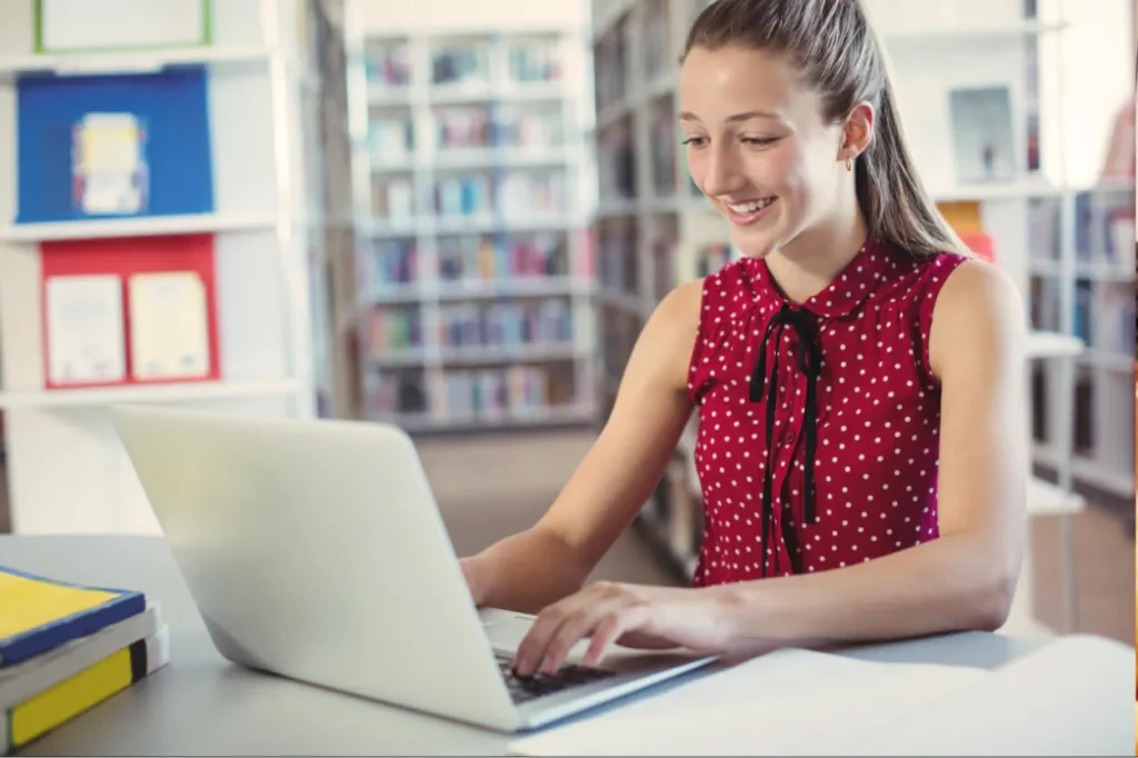 Teacher in classroom using laptop